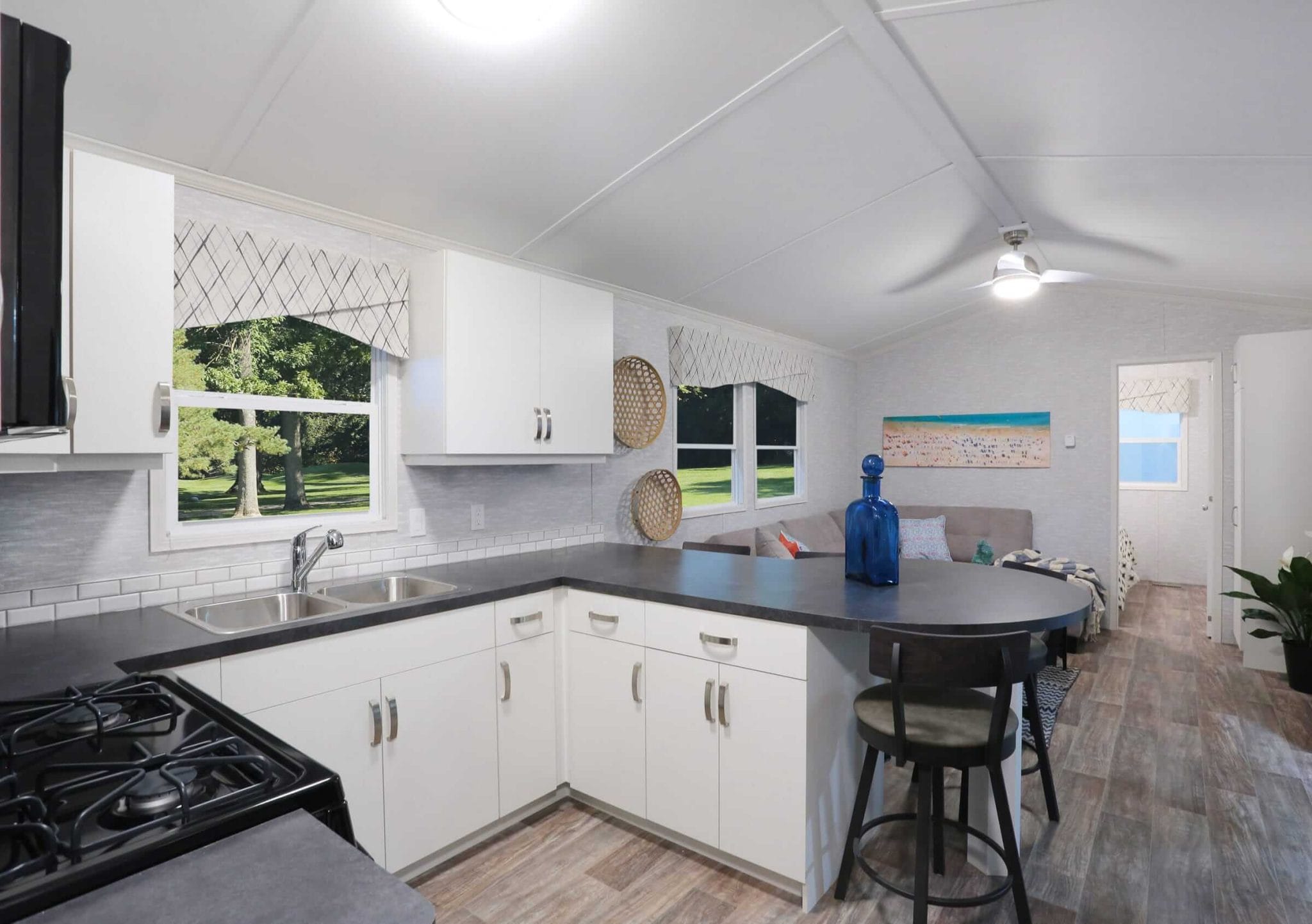 Kitchen and living room of a Frontier Series manufactured home, showcasing an open layout with modern design elements.