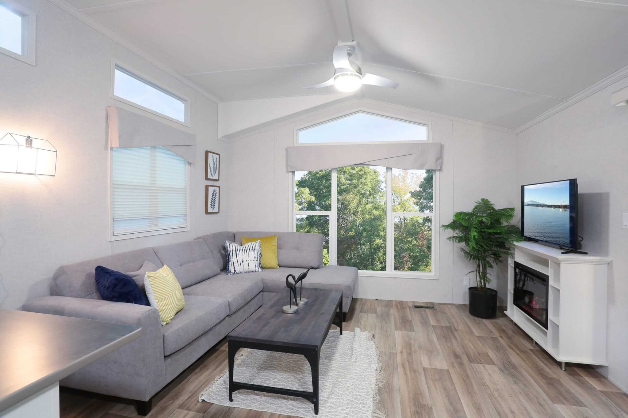 Living room in a manufactured home featuring a couch, coffee table, and television, showcasing the Frontier Series design.