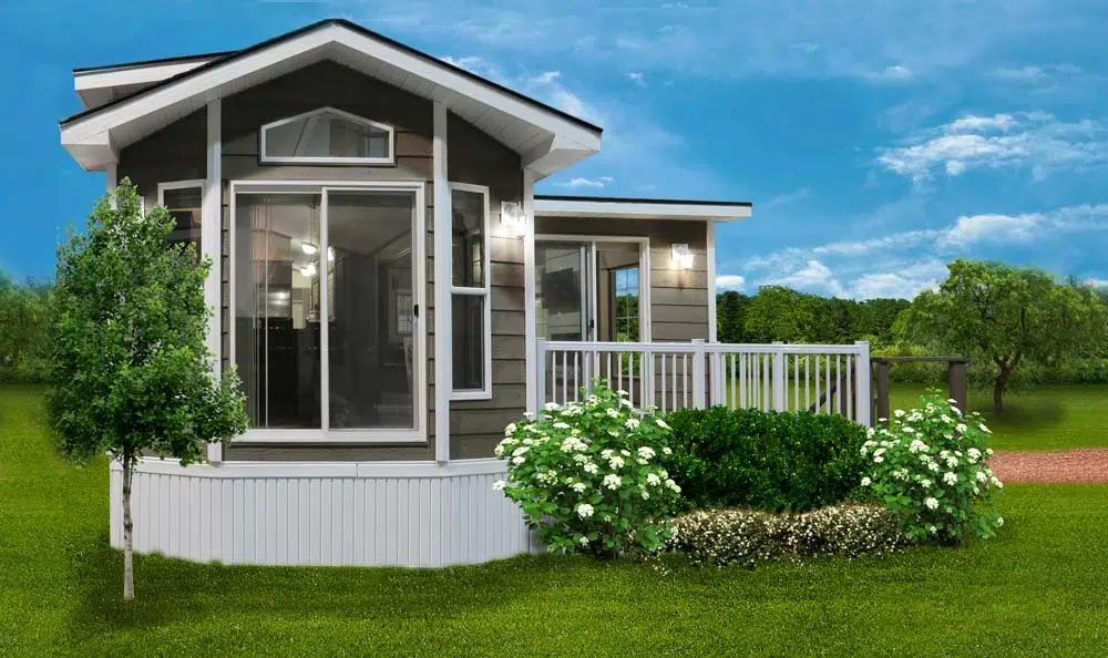 Park Model Homes of a small house featuring a porch and deck, showcasing its cozy outdoor living space.
