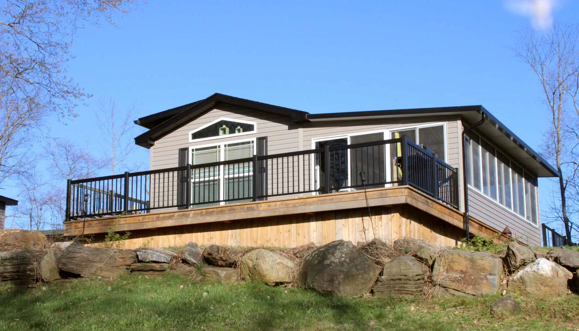 Small cabin featuring a balcony and deck, showcasing a Park Model Homes design.