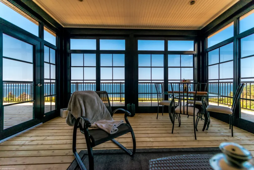 Sunroom featuring a table and chairs with a view of the ocean, showcasing WeatherMaster™ Windows.