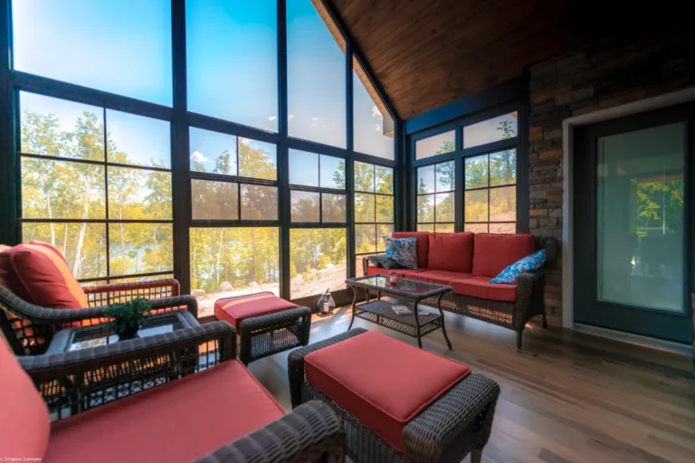 Porch Conversions create a cozy space with big glass windows, wicker seating, and beautiful outdoor views, combining comfort with nature.