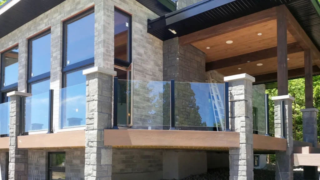 Modern home featuring glass walls and a balcony, showcasing Aluminum Railing with Glass for a sleek design.