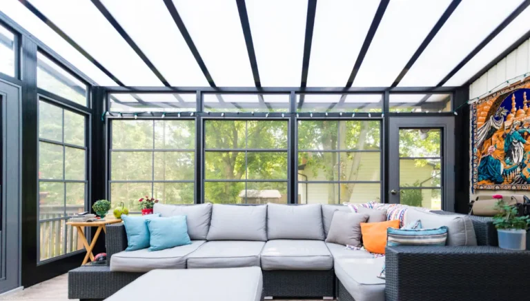 A sunroom featuring a couch and coffee table, showcasing the 3-Season Sunroom Vinyl design.