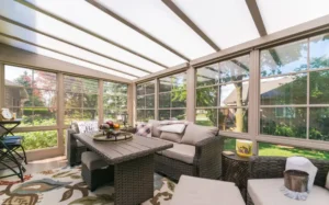 A 3-season sunroom featuring wicker furniture and a table, designed for comfort and relaxation in a bright, airy space.